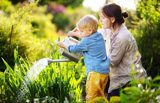 Mutter und Sohn pflegen den Garten