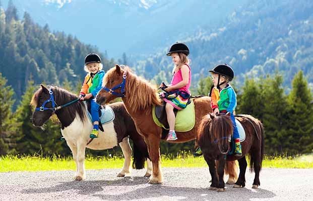 Drei Kinder reiten auf Ponys
