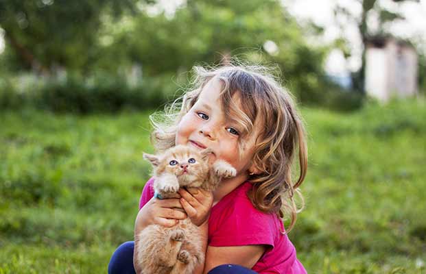 Mädchen hält Katze im Arm