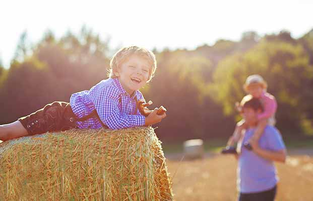 Vater und Kinder genießen die Zeit auf einem Strohballen